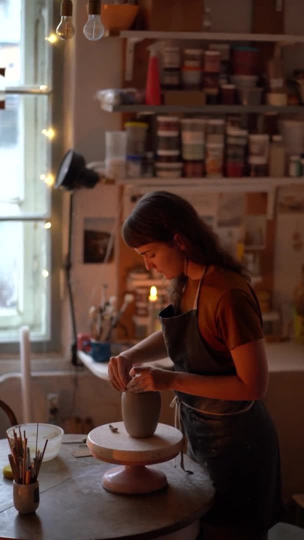 セラミック花瓶を形成する陶芸スタジオの創造的な女性の所有者。女性陶芸家はワークショップで仕事を楽しむ — ストック動画