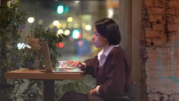 Elfoglalt nő dolgozik laptopon a kávézóban. A fiatal afrikai író vagy újságíró cikket készít a kávézóban — Stock videók