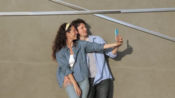 Coppia divertente scattare selfie sulla fotocamera dello smartphone e postare foto sui social media felice ridere all'aperto — Video Stock