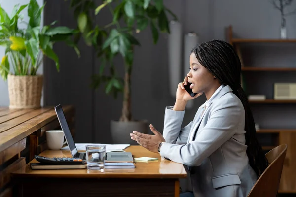年轻的非洲裔女办公室工作人员使用手机，在工作场所打电话 — 图库照片