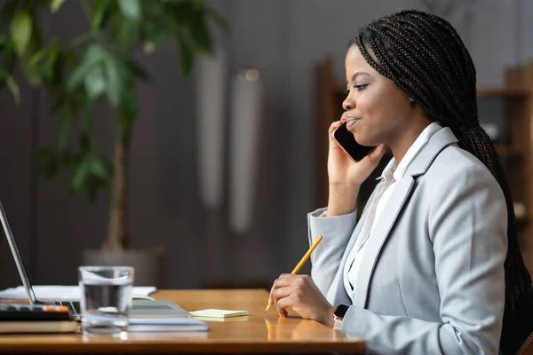 成功的女商人或秘书与老板通电话时，办公室桌上坐着写着便条 — 图库照片