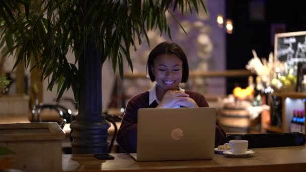 Glimlachende zakenvrouw praat golf hallo tijdens online videogesprek via laptop computer van cafe — Stockvideo