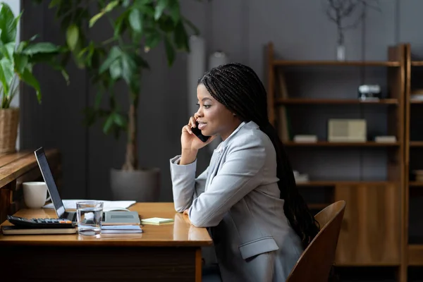 非洲女商人在任职期间通过电话从商业伙伴那里听到好消息 — 图库照片