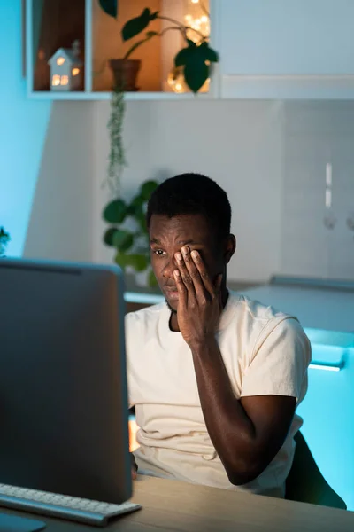 Müde afro männliche Arbeiter oder Studenten, die Überstunden am Computer machen, brauchen Ruhe und Schlaf überlastet zu Hause — Stockfoto