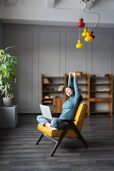 Equilibrio entre trabajo y vida. Mujer freelancer feliz haciendo ejercicios de relajación en el lugar de trabajo remoto —  Fotos de Stock