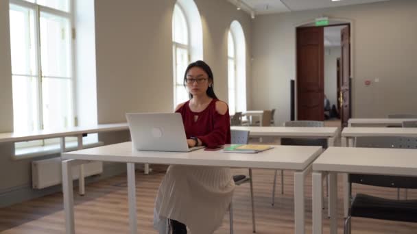 Frilansare ung vuxen flicka arbetar i co-working utrymme upptagen skriva på bärbar dator sitter på öppet kontor — Stockvideo