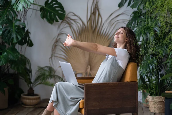Zmęczony kobieta freelancer rozciąganie ramiona relaks podczas pracy na laptopie w przytulnym ogrodzie — Zdjęcie stockowe