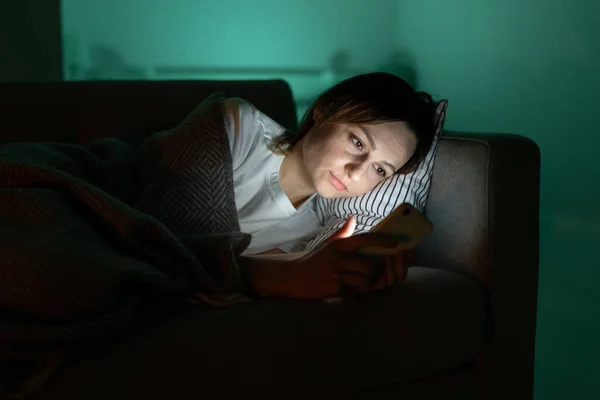 Addicted from social media woman surf internet in dark room at night. Sleep disorder problem concept — стоковое фото