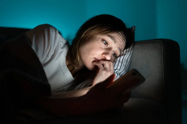 Úzkostlivá žena v posteli pomocí smartphone v noci, nemůže přestat rolování zpravodajských médií před spaním — Stock fotografie