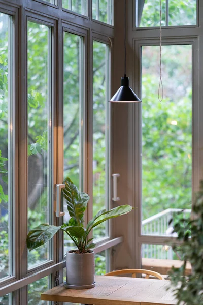 Przytulne wnętrze restauracji z projektowaniem drewniany stół duże okna lampy, roślin w ekologicznym stylu naturalnym — Zdjęcie stockowe