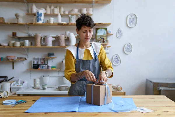 Kobieta pracuje w sklepie ceramiki rzemieślniczej lub studio pakowania ceramiki w pudełku na prezent dla konsumenta — Zdjęcie stockowe