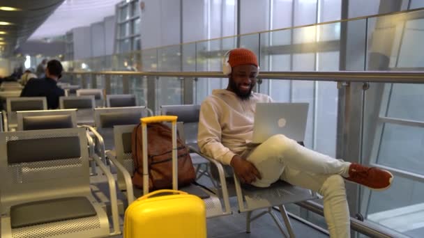 Uśmiechnięty Afro Amerykański Hipster Siedzący Holu Terminalu Lotniska Przy Użyciu — Wideo stockowe
