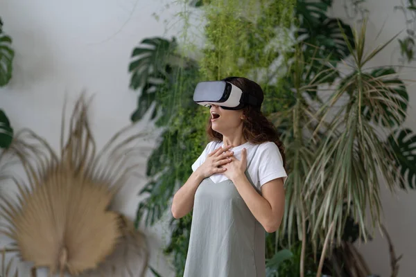 在Vr耳机里的感情震惊的女孩沉浸在充满情感和印象的3D虚拟世界中 在第一次虚拟现实体验中尖叫 在家庭花园使用互动技术的妇女 — 图库照片