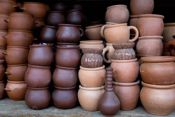 Rows of traditional handmade clay pots and earthenware jar on market or bazaar. Organic way making earthen pottery to store wine or olive oil, as well as everyday objects.