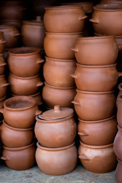 Rows of traditional handmade clay pots and earthenware jar on market or bazaar. Organic way making earthen pottery to store wine or olive oil, as well as everyday objects.