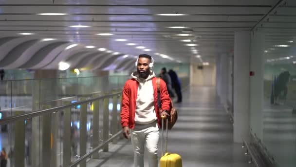 Юний Стильний Афроамериканець Навушниках Тягне Валізу Терміналі Аеропорту Йде Воріт — стокове відео