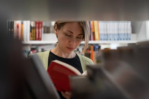 Scandinavian Middle Aged Woman Looking Book Library Bookshelf Female Mature — Stockfoto