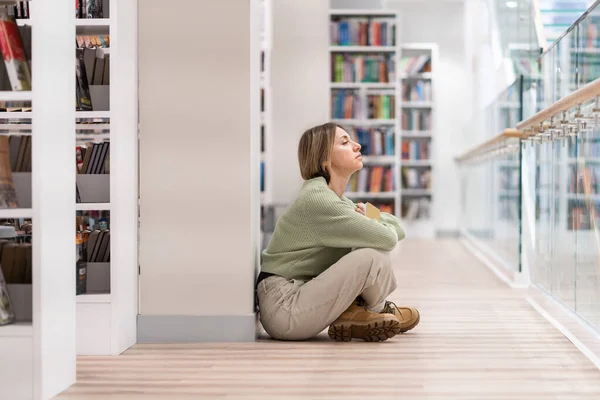 Задумчивая Женщина Средних Лет Сидящая Полу Современном Интерьере Библиотеки Книгой — стоковое фото