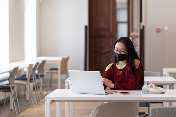 코비온 코로나 바이러스가 유행하는 보호용 마스크를 아시아인 여학생 노트북을 사용하여 — 스톡 사진