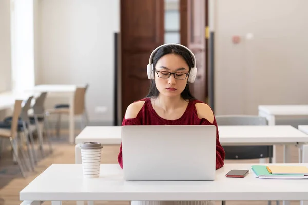 Concentrated Asian Woman Headphones Watching Webinar Video Course Laptop Coworking — Fotografia de Stock
