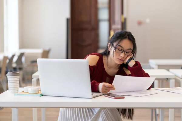 Tired Asian Female Student Sitting Library Reading Printed Paper Materials — Stockfoto