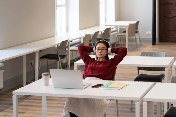 Young Asian Female Student Wearing Headphones Relaxing Hands Head While — Fotografia de Stock