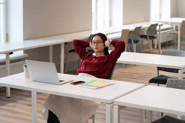 Young Asian Female Student Wearing Headphones Relaxing Hands Head While — Stockfoto