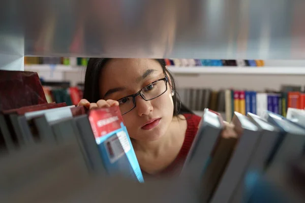 Женщина Студентка Выбирает Книгу Книжной Полки Колледже Университетской Библиотеке Исследований — стоковое фото