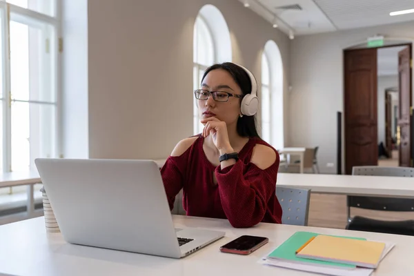 Focused Asian Girl Student Wear Headphones Look Laptop Watch Online — Stockfoto