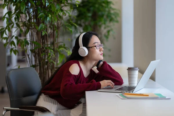 Asian Female Freelancer Headphones Looking Laptop Screen While Working Remotely — Fotografia de Stock