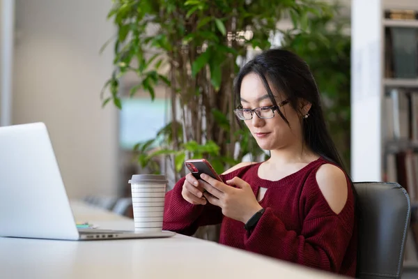 Happy Asian College Girl Using Smartphone While Studying Laptop Public — Fotografia de Stock