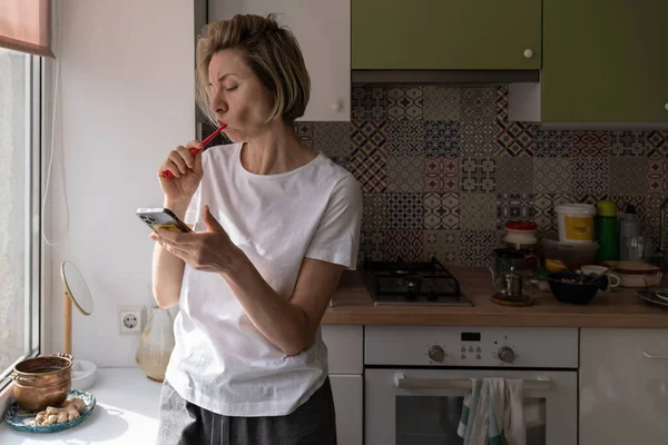 Middle Aged Scandinavian Woman Brushing Teeth Morning Using Smartphone Mature — Foto Stock