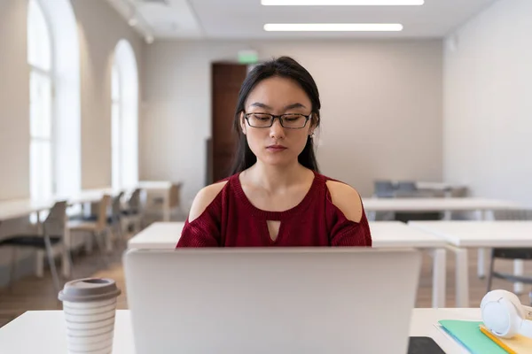 Fokuserad Pensiv Asiatisk Flicka Bär Glasögon Sitter Vid Biblioteksbordet Framför — Stockfoto