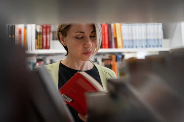 Scandinavian Middle Aged Woman Looking Book Library Bookshelf Female Mature — Stockfoto