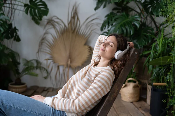 Young Woman Closed Eyes Put Hand Back Wearing Wireless Headphones — Photo