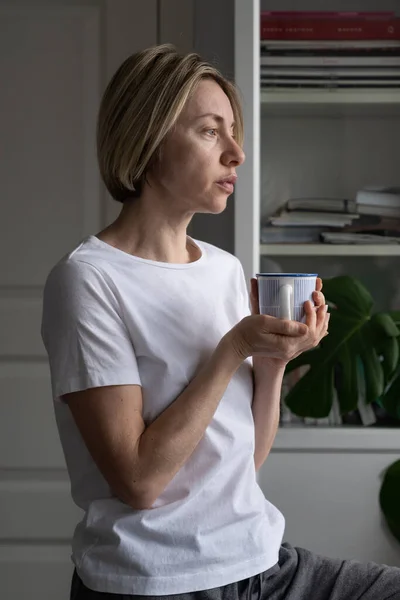 Medelålders Skandinavisk Kvinna Tittar Genom Fönstret Och Känner Sig Ledsen — Stockfoto