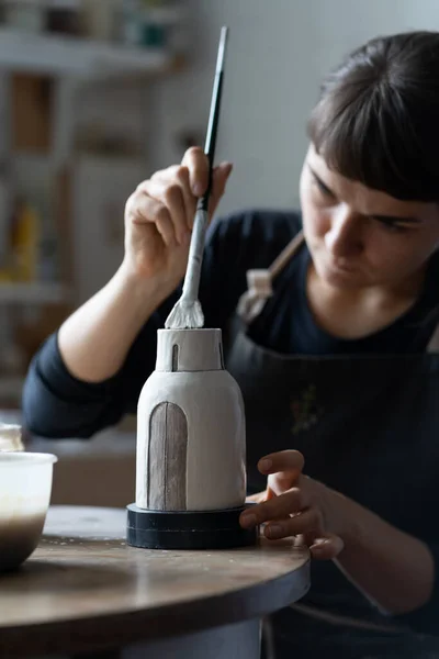 Happy Concentrated Young Craftswoman Paints Clay Vase Using Paintbrush Skilled — Stockfoto