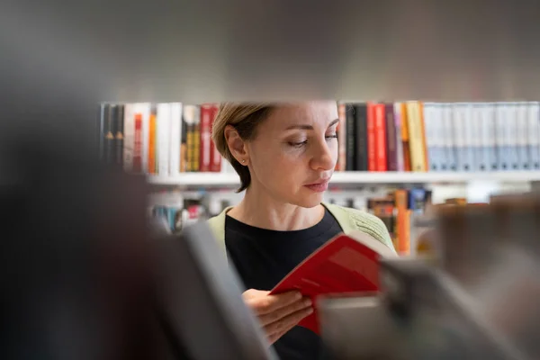 Scandinavian Middle Aged Woman Looking Book Library Bookshelf Female Mature — ストック写真