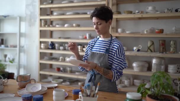 Focused Woman Painting Clay Plate Different Paint Shaping Sculpturing Earthenware — Stock video