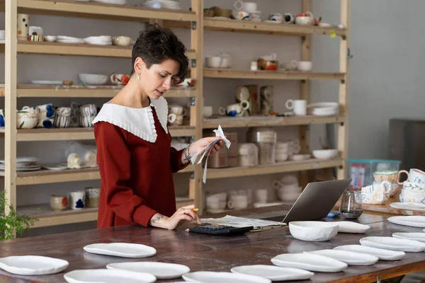 Young Busy Focused Woman Entrepreneur Doing Paperwork Female Artisan Ceramics — Zdjęcie stockowe