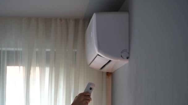 人们把手伸向空调机 打开装置 房主检查公寓里的操作调节器 试图捕捉暖空气 妇女牵手控制空调机的工作 — 图库视频影像