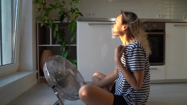 Молода Жінка Футболці Сидить Перед Вентилятором Блондинка Намагається Охолодити Потік — стокове відео