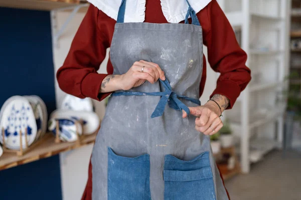 Γυναίκα Κεραμίστρια Δένει Την Ποδιά Της Πριν Δουλέψει Ακατέργαστο Πηλό — Φωτογραφία Αρχείου