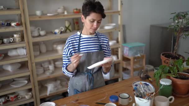 Zaostřená Žena Hrnčíř Mistr Drží Štětec Malování Keramiky Zdobení Ručně — Stock video