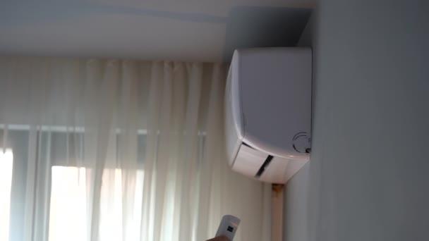 人们把手伸向空调机 打开装置 房主检查公寓里的操作调节器 试图捕捉暖空气 妇女牵手控制空调机的工作 — 图库视频影像