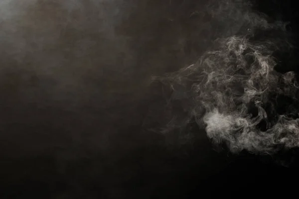黒い背景に白い煙と霧の濃いふわふわのパフ 抽象的な煙雲 動きが焦点からぼんやりとした 機械からの喫煙の打撃ドライアイスフライと空気中でなびく 効果的なテクスチャ — ストック写真