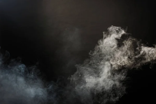 Dense Fluffy Puffs of White Smoke and Fog on Black Background, Abstract Smoke Clouds, Movement Blurred out of focus. Smoking blows from machine dry ice fly and fluttering in Air, effect texture