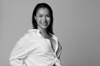 40 'lı yılların Asya portresi LGBTQIA + Kadın siyah saçlı, beyaz kısa pantolonlu. Transseksüel 30 'lu yaşlarda kadın mutlu bir gülümseme hisseder. Birçok poz beyaz arka planda yalnız bırakılır.