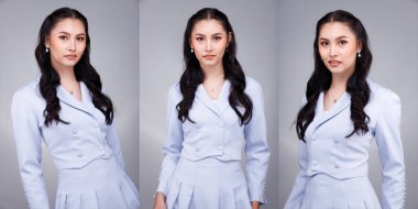 20 'li yaşların Asyalı güzel, bronzlaşmış vücut portresinin yarısı siyah kadın saçı pastel mavi resmi elbise giyer. Ofis Kadını ifadesiyle güler yüzlü mutlu iş yerinde kendine güvenen çoğu kişi gri arka planda poz verir.