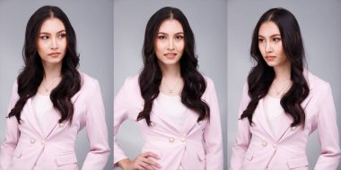 20 'li yaşların Asyalı güzel, bronzlaşmış vücut portresi siyah saçlı kadın pastel pembe resmi elbise giyiyor. Ofis Kadını ifadesiyle güler yüzlü mutlu iş yerinde kendine güvenen çoğu kişi gri arka planda poz verir.